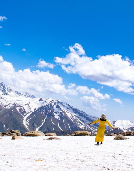 rear-view-woman-standing-snowcapped-mountain-against-sky_1048944-4635334