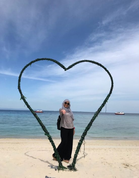 woman-standing-by-heart-shape-beach_1048944-3519243